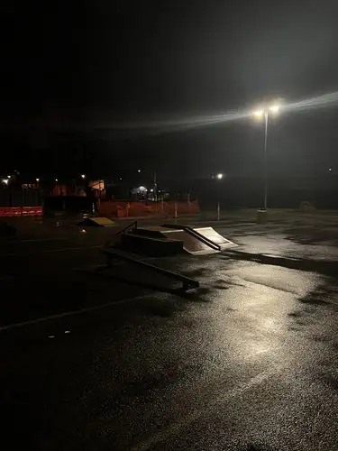 Night falls, leaving the skatepark wet and waiting.